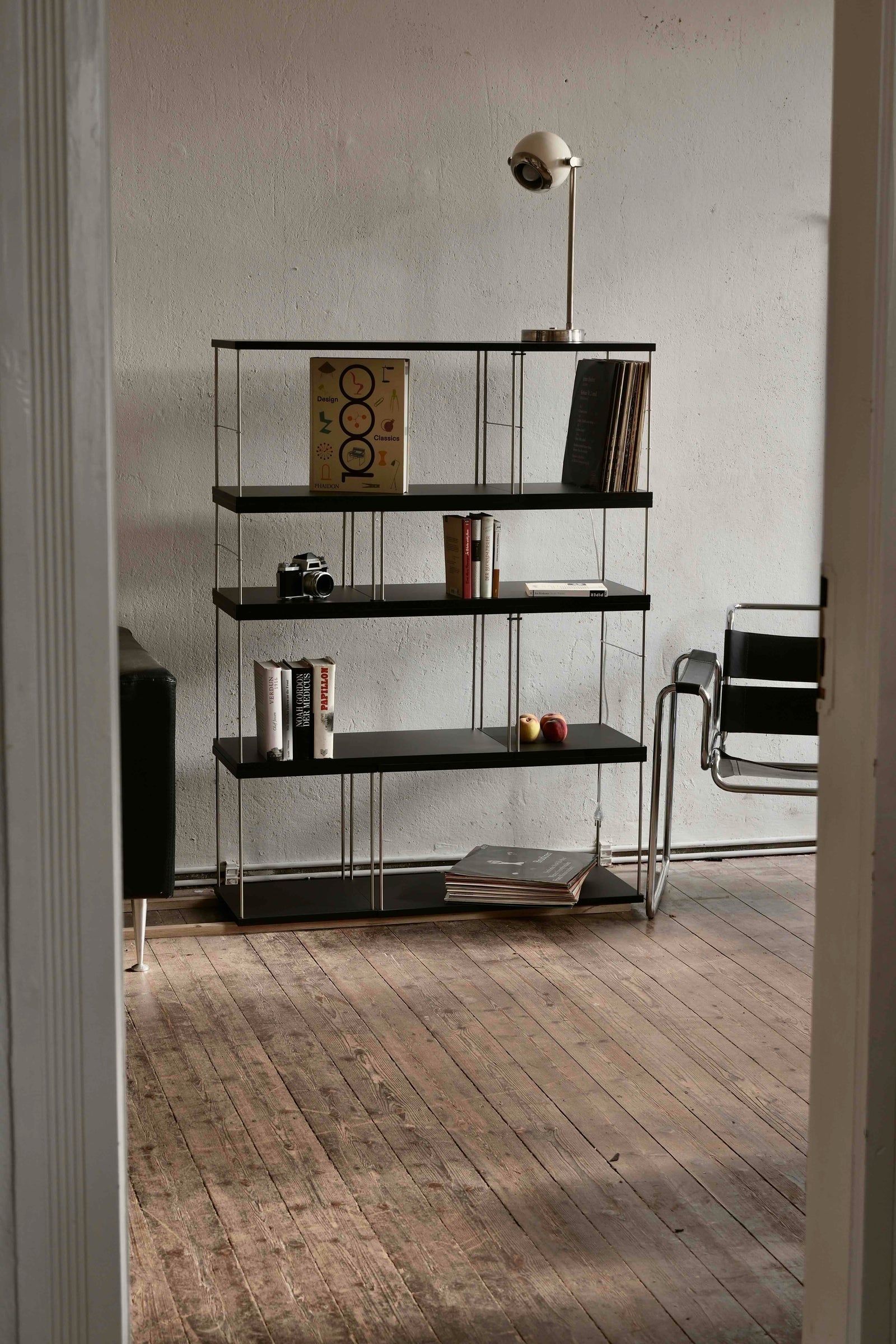 Ein schwarzes Bloks Regal mit Büchern, Schallplatten und Pfirsichen